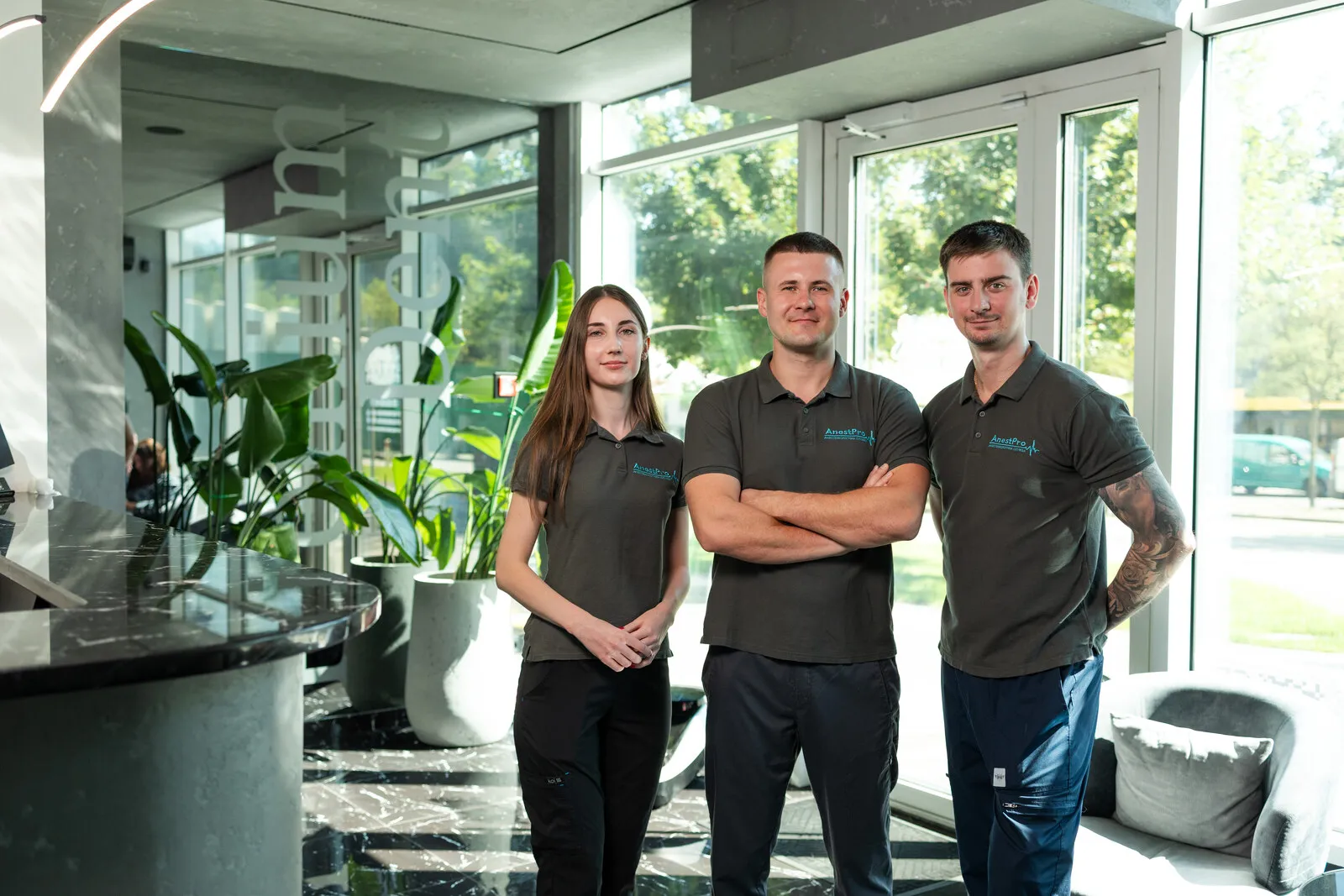 Троє фахівців команди AnestPro у фірмовій формі в холі клініки